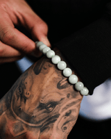 Person wearing a white beaded jade bracelet