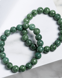 Green beaded jade bracelet on a white surface