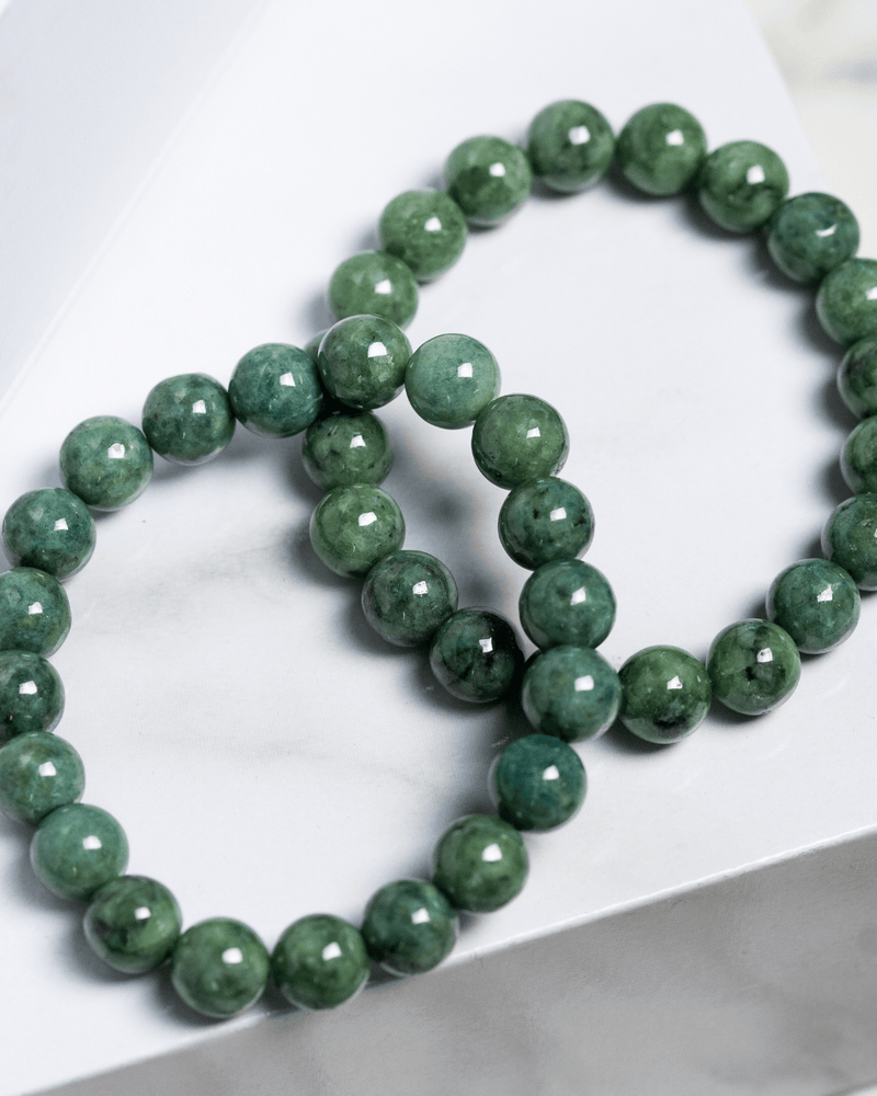 Green beaded jade bracelet on a white surface
